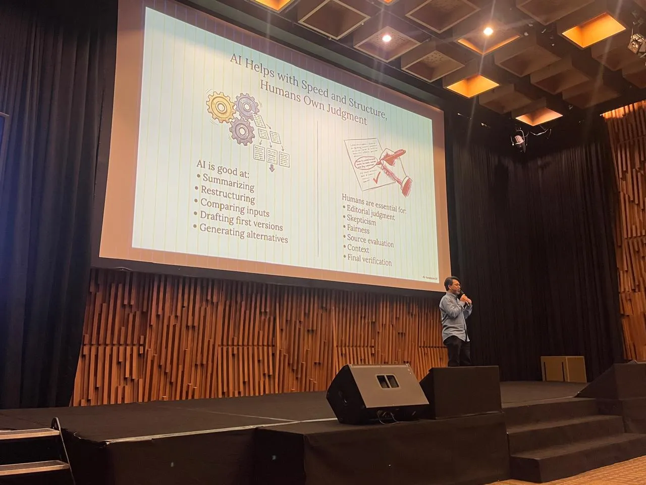 Hazmi delivering AI training on stage, with a slide about AI assistance and human judgment.